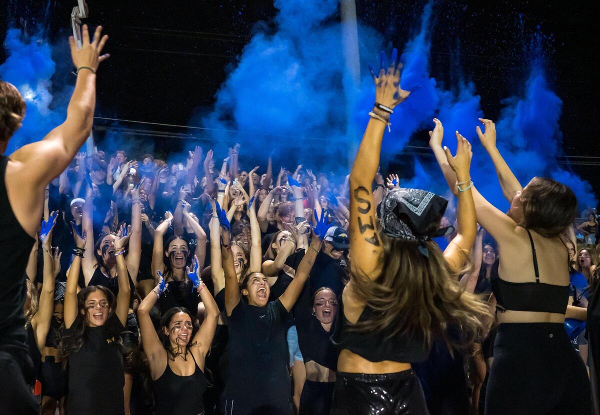 Casa Roble Rams student fans throw blue powder in the air to celebrate at the start of the second half at a home game in 2023.