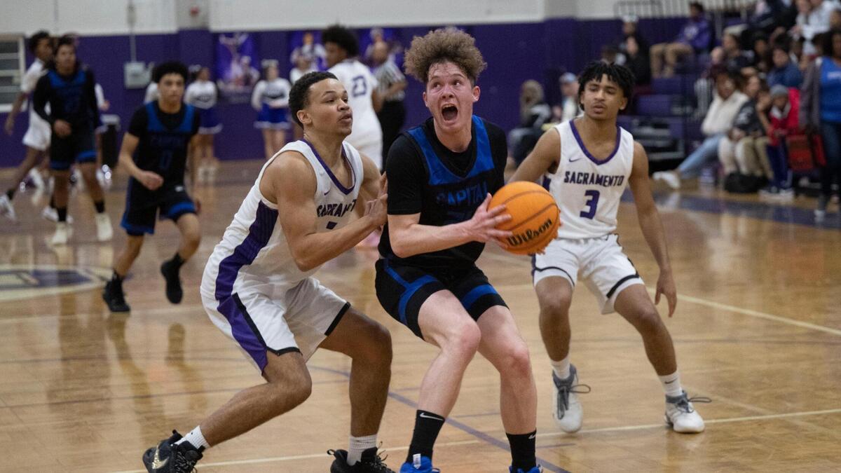 Capital Christian’s Jaylen Valdez, center, looks for an opening to shoot in January as the Cougars played the Sacramento Dragons in a Capital Athletic League basketball game in Oak Park.