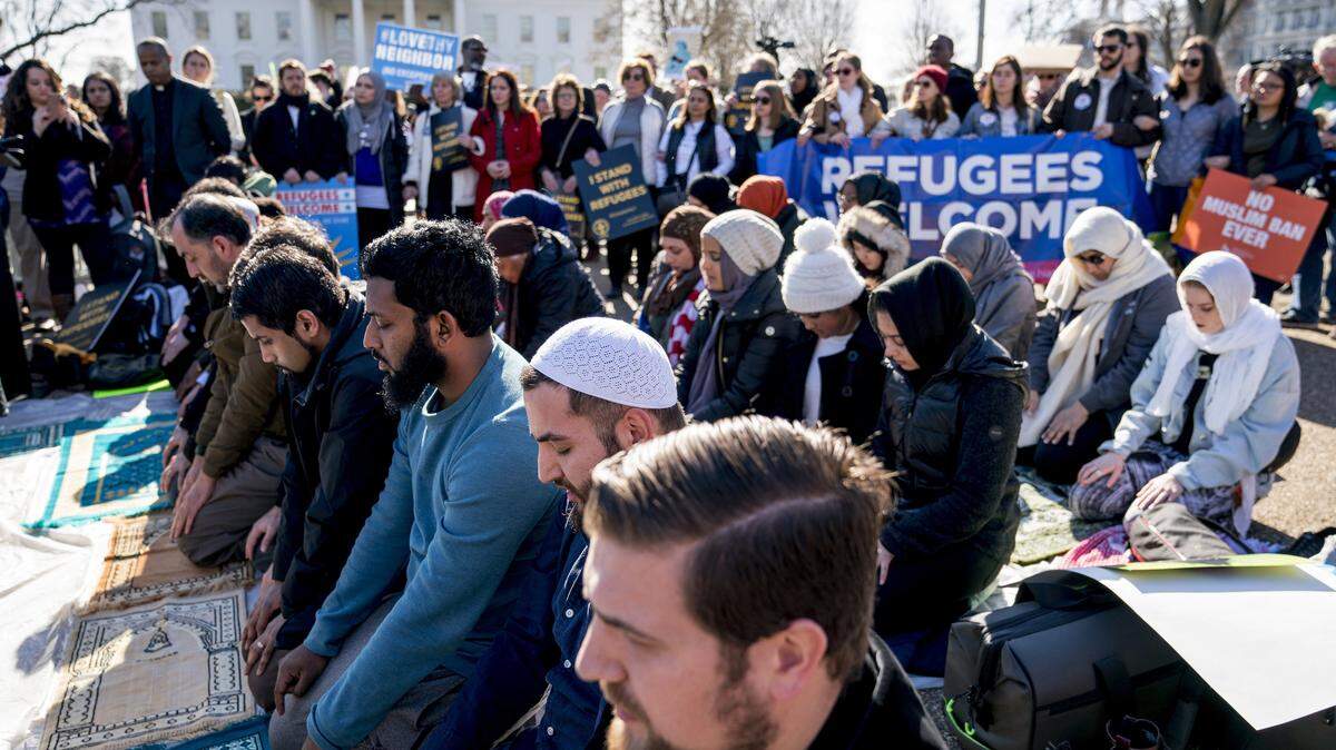 Supporters surround a group praying outside the White House on Jan. 27, 2018, during a rally on the one-year anniversary of the Trump administration’s first travel ban on citizens from seven Muslim-majority countries.