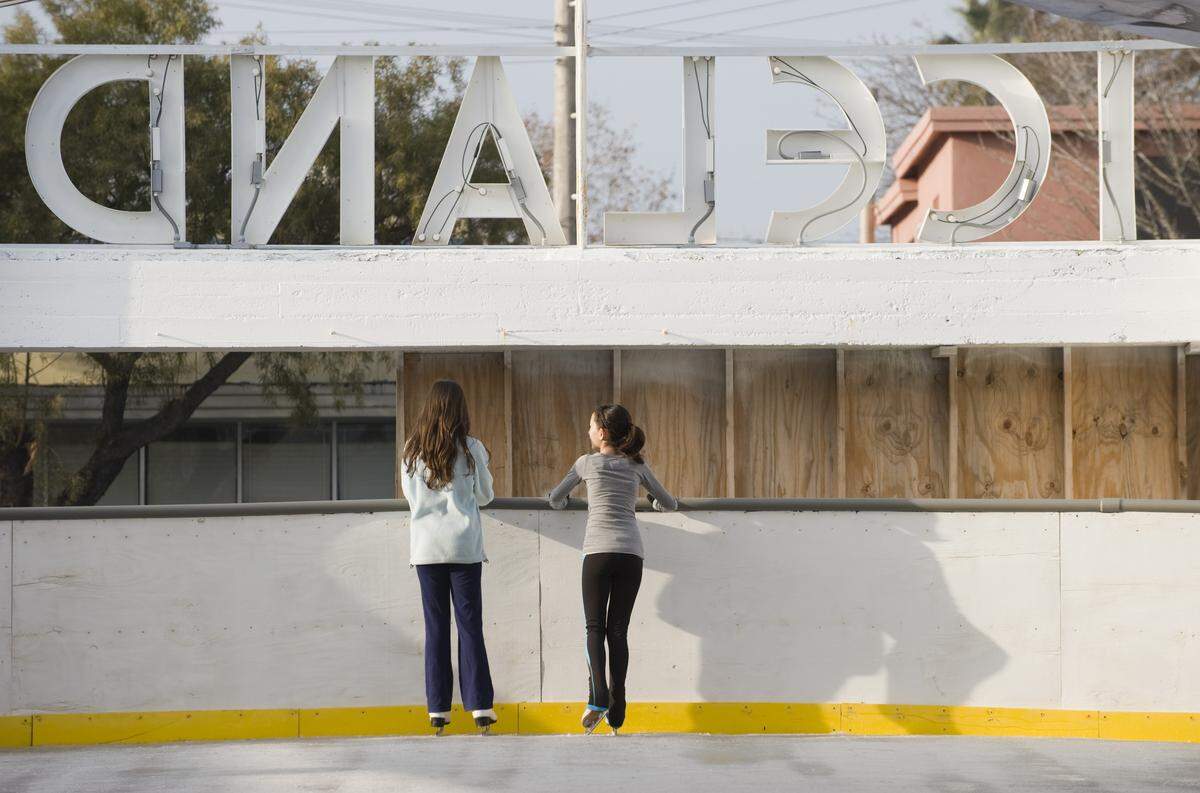 Competitive skating friends Bria Fletcher and Anli Ni, both 12, get a chance to catch up after the reopening of the Iceland Ice Skating Rink in January 2011, less than a year after it burned. 