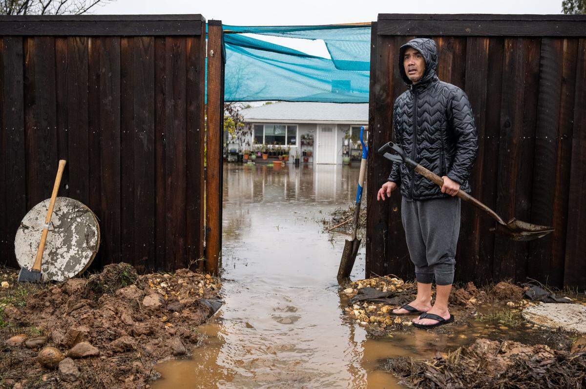 Danny Saechao gets assistance from Sacramento Metropolitan Fire District first responders during flooding at his home on the 7800 block of Excelsior Road in Sacramento County on Saturday, Dec. 31, 2022, as heavy rainfall from an atmospheric river inundates the area. Saechao said it’s their second year at the house, and flooding during a storm last year did not reach the current level of water.
