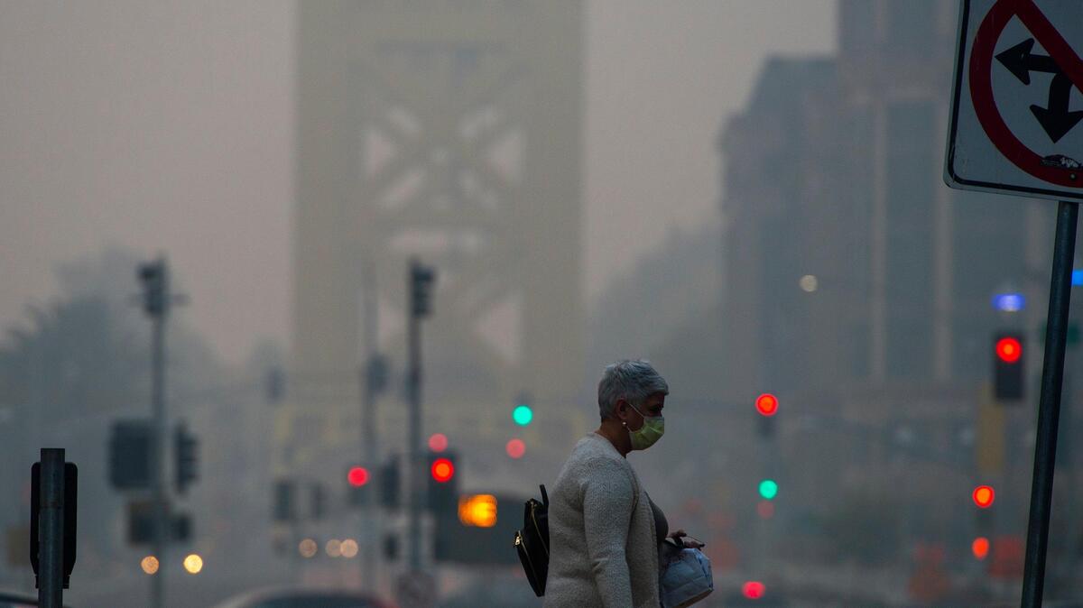 Stateworker Evelia Limeberger wears a mask to protect herself as she walks through the Capitol Mall near 5th Street as Sacramento experienced a bad air quality day after on Thursday, November 15, 2015.