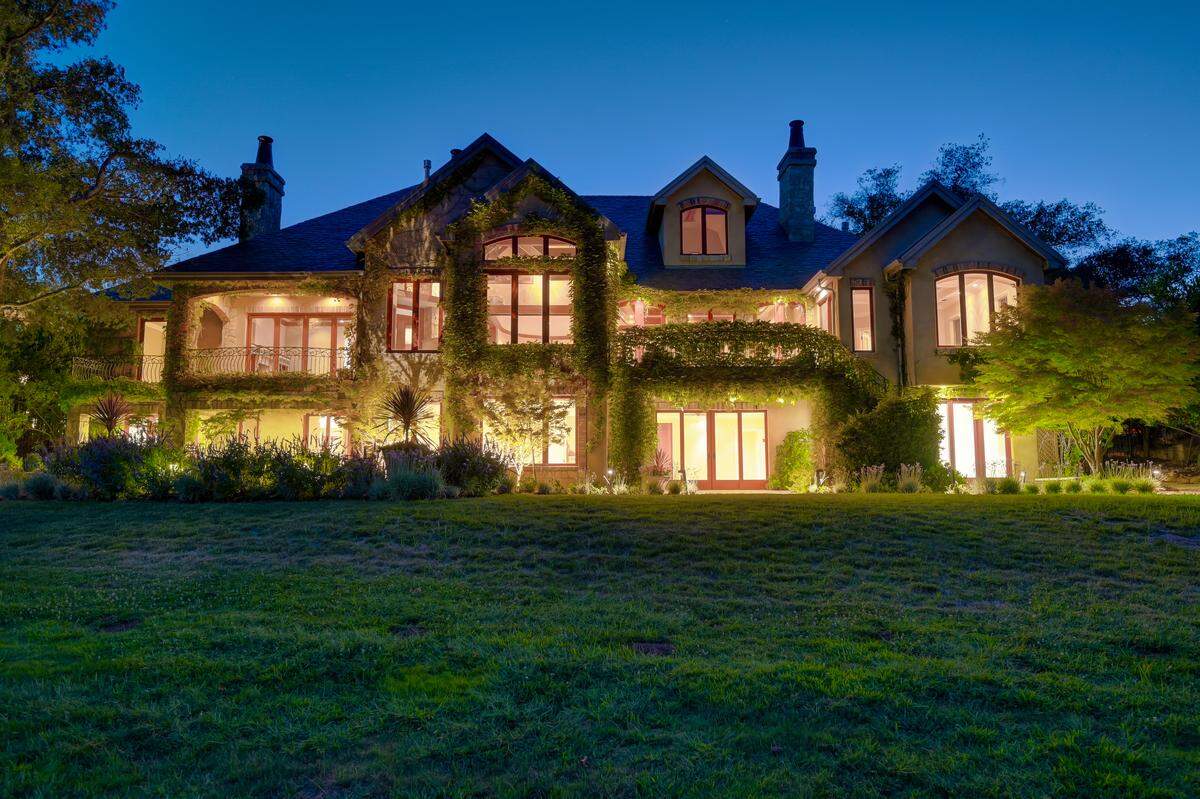The 7,365-square-foot home lights up from the back. This would be the view from the sixth fairway of Serrano Country Club’s golf course.
