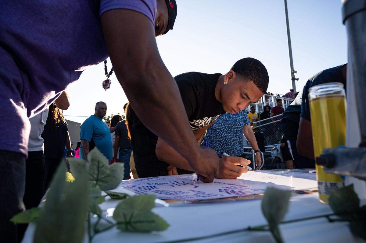 Christian Harris, 16, son of Inderkum High School football coach Reginald Harris, writes a message to former assistant coach Greg Najee Grimes, a 31-year-old former football star at Inderkum and Boise State University, during a vigil on Tuesday, July 5, 2022, in Sacramento. He was more like a brother than a coach, Harris said. You know, this parking lot is full its really crazy how many people he touched in the community. Grimes was killed and four other people injured during a shooting outside a downtown Sacramento nightclub at 16th and L streets just before 2 a.m. Monday.