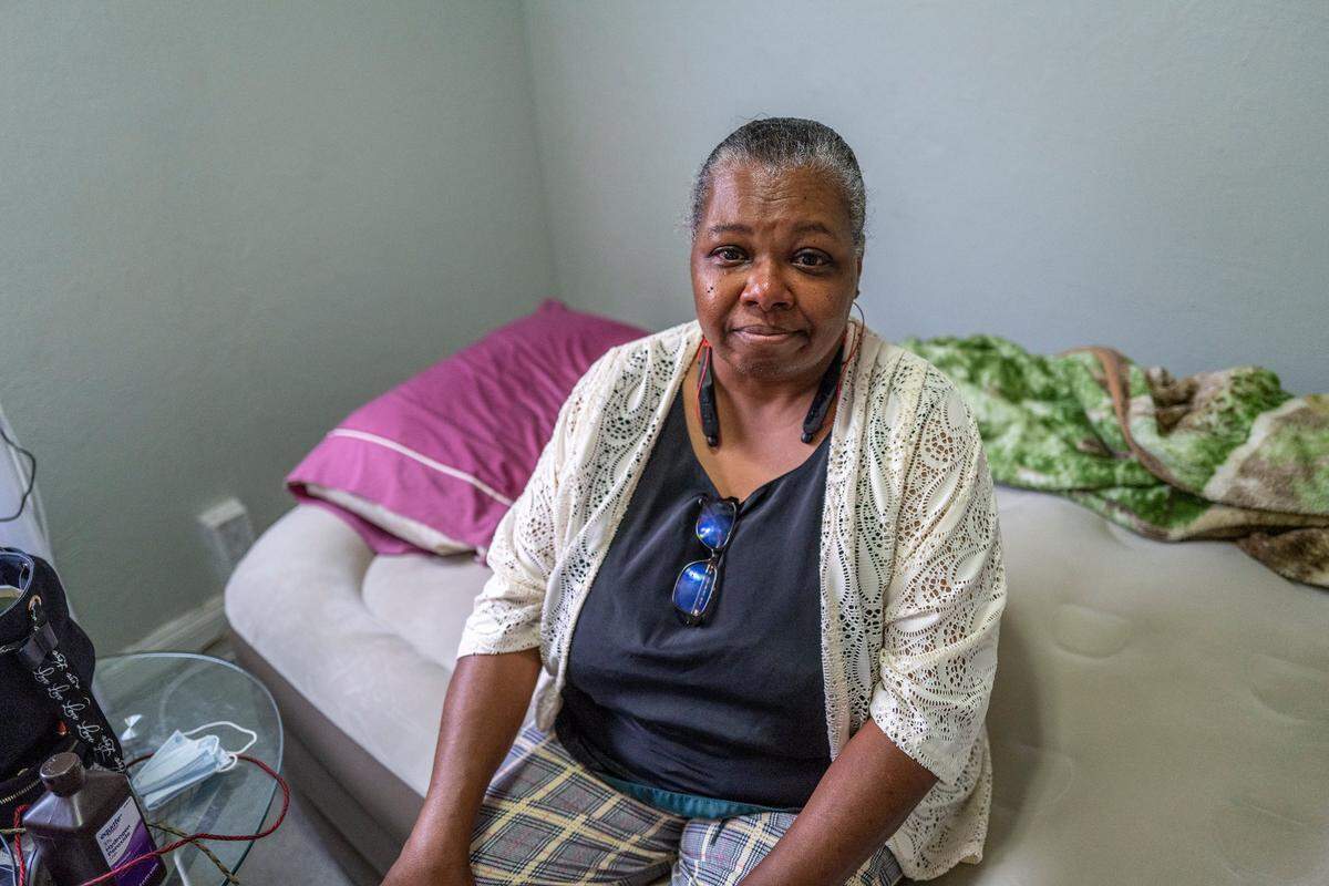Tears stream down the face of Lenora Jackson earlier this month as she sits on the air mattress that she had to begin sleeping on after a bedbug infestation at her rental house. Jackson said she cries almost every day over whether she will be evicted from the Oak Park home.
