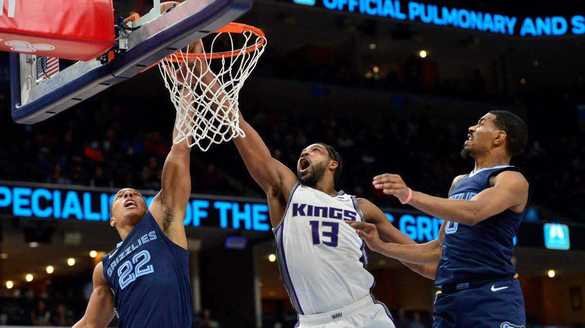 Memphis Grizzlies guard Desmond Bane (22) and Sacramento Kings center Tristan Thompson (13) reach for the ball as guard De’Anthony Melton (0) moves for position in the first half of an NBA basketball game Sunday, Nov. 28, 2021, in Memphis, Tenn. (AP Photo/Brandon Dill)