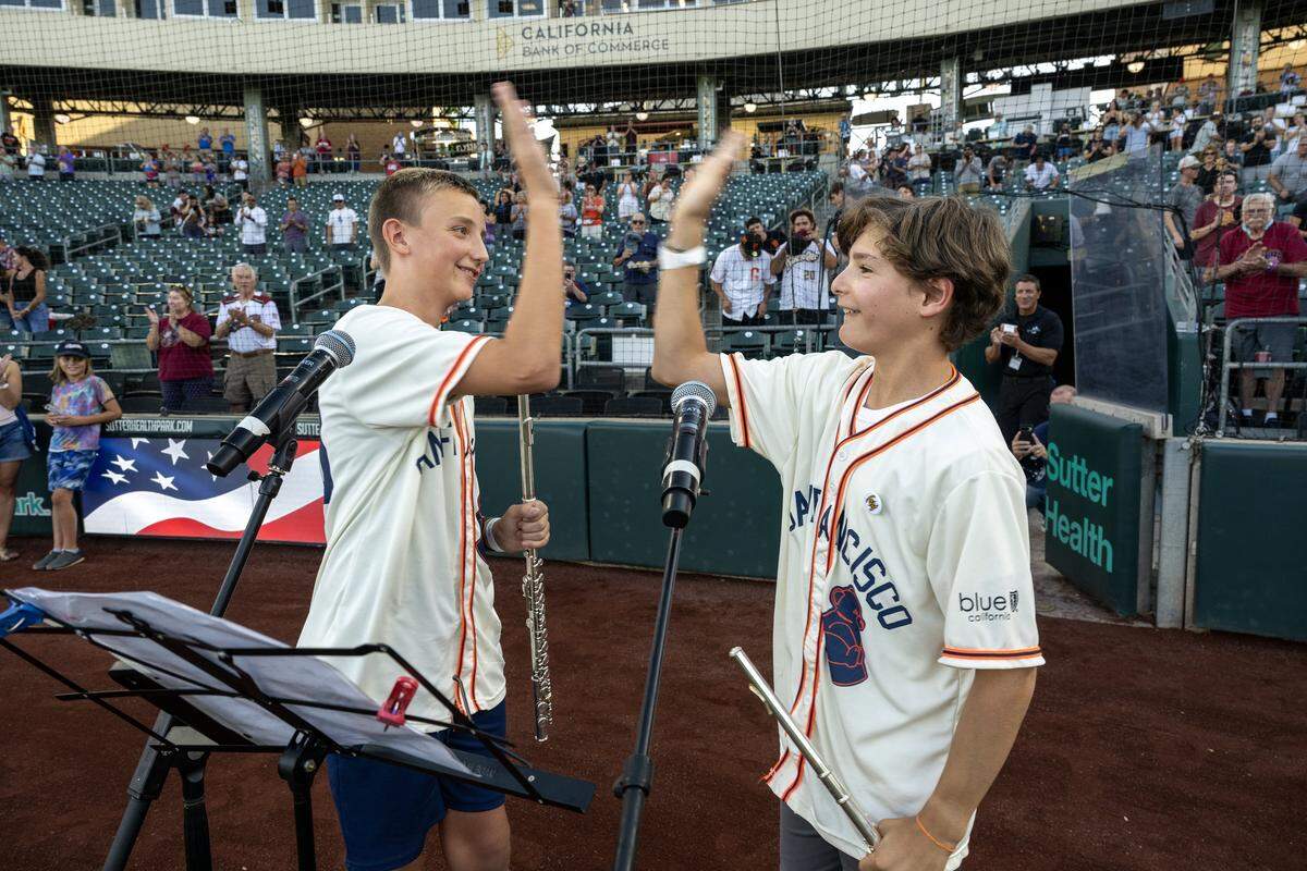 Maxwell Jones, left, high fives Jake Forest after performing the national anthem before the Sacramento River Cats played the El Paso Chihuahuas on Aug. 20.