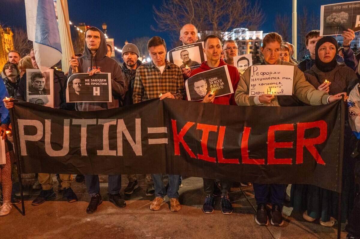 A sign calls Russian President Vladimir Putin a killer at a candlelight vigil in downtown Sacramento on Tuesday to mourn the loss of Alexei Navalny, the Russian opposition leader who died in an Arctic penal colony earlier this month.&nbsp;