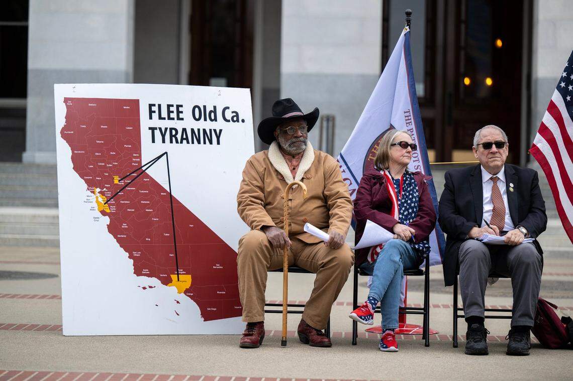 New California State supporters Loyd Kennedy, Tina Hessong and Paul Preston sit Tuesday next to a map representing how the state of California would be split into two states during a rally in support of the proposal at the state Capitol.