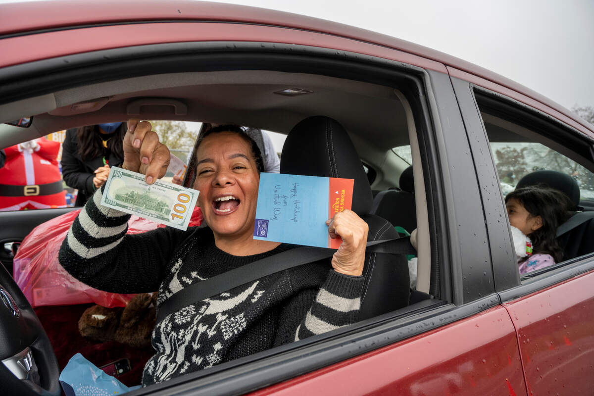 Adriana Sala, reacts after receieving $100 in cash from the United Way at the Yolo County Children’s Alliance 2021 Annual Holiday Toy Distribution on Saturday, Dec. 18, in West Sacramento. Thanks to the giving spirit from many public and private organizations, as well as individual donors, the event was able to provide an estimated 3,000 toys for 965 children.