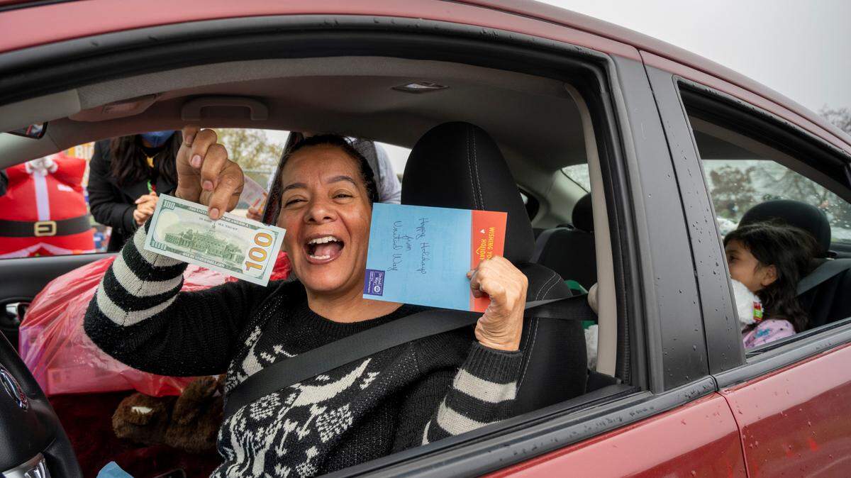 Adriana Sala, reacts after receieving $100 in cash from the United Way at the Yolo County Children’s Alliance 2021 Annual Holiday Toy Distribution on Saturday, Dec. 18, 2021 in West Sacramento. Thanks to the giving spirit from many public and private organizations, as well as individual donors, the event was able to provide an estimated 3,000 toys for 965 children.