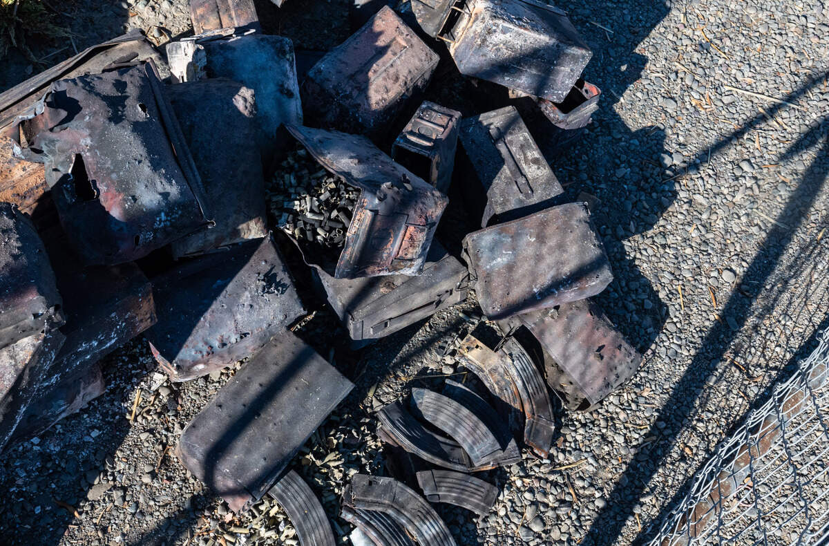 Ammunition boxes, some with burned rounds inside, and magazines form a jumbled pile at the Esparto fireworks explosion site on Friday, July 18, 2025.