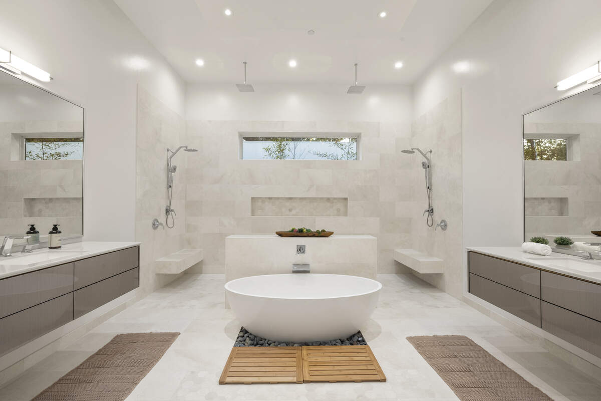 A spa-style bath leans into the home’s high-end finishes, with floating vanities and an oversized shower designed for everyday comfort and wow factor.
