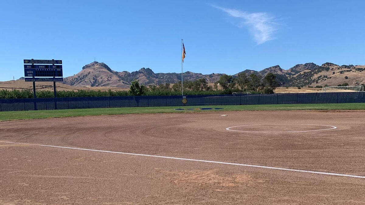 The Sutter Buttes rise behind the outfield fence at Sutter High School’s softball field.