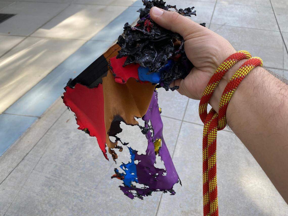 The Rev. Matthew Woodward, dean of the cathedral at Trinity Cathedral, holds the remains of one of the Sacramento church’s Pride rainbow flags, which was found burned Saturday morning.