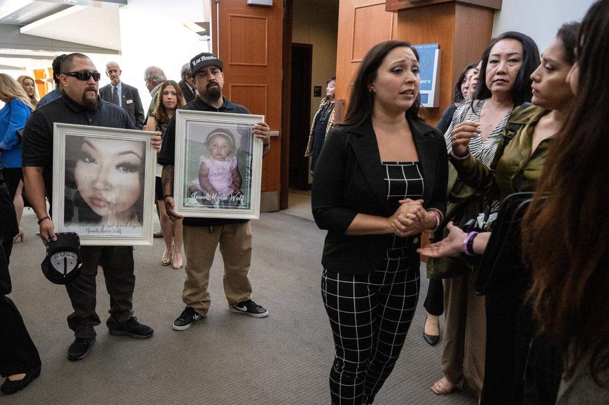 As Jacob Chavez and Johnny Tabular hold photographs of their niece Jewels Marie Wolf, the victim’s mother Regina Leah Chavez speaks with family and friends after the sentencing of Nathanial Evan Cabacungan, 22, at Placer Superior Court on Tuesday in Roseville, for second-degree murder for the fentanyl death of her daughter. Cabacungan, 22, was sentenced to 15 years to life in prison for what is believed to be the first murder conviction in California for a fentanyl death.