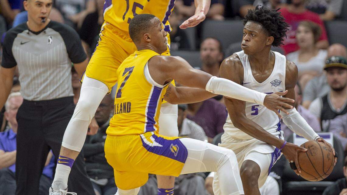 The Los Angeles Lakers' Demarcus Holland defends against Kings guard De'Aaron Fox, right, in the fourth quarter of a California Classic summer league game Monday at Golden 1 Center in Sacramento.