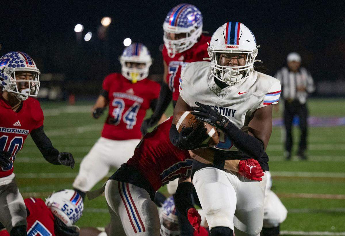 Destiny Christian Lions’ Caleb Hill (0) carries the ball past Christian Brothers Falcons’ Gunnar Marsh (12) for a five-yard rushing touchdown a Sac-Joaquin Section Division III quarterfinal game on Friday, Nov. 15, 2024, in Sacramento.