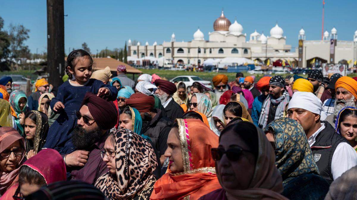 People fill one side of Bradshaw Road as they walk past the Sacramento Sikh Society temple in Vineyard on Sunday, March 26, 2023, during the society’s first Nagar Kirtan parade.