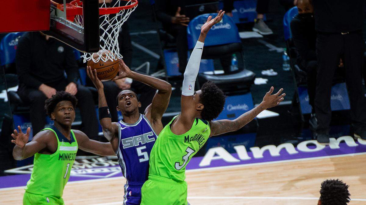 Sacramento Kings guard De’Aaron Fox (5) is defended by Minnesota Timberwolves forward Jaden McDaniels (3) in the third quarter during a game at Golden 1 Center on Tuesday, April 20, 2021 in Sacramento.