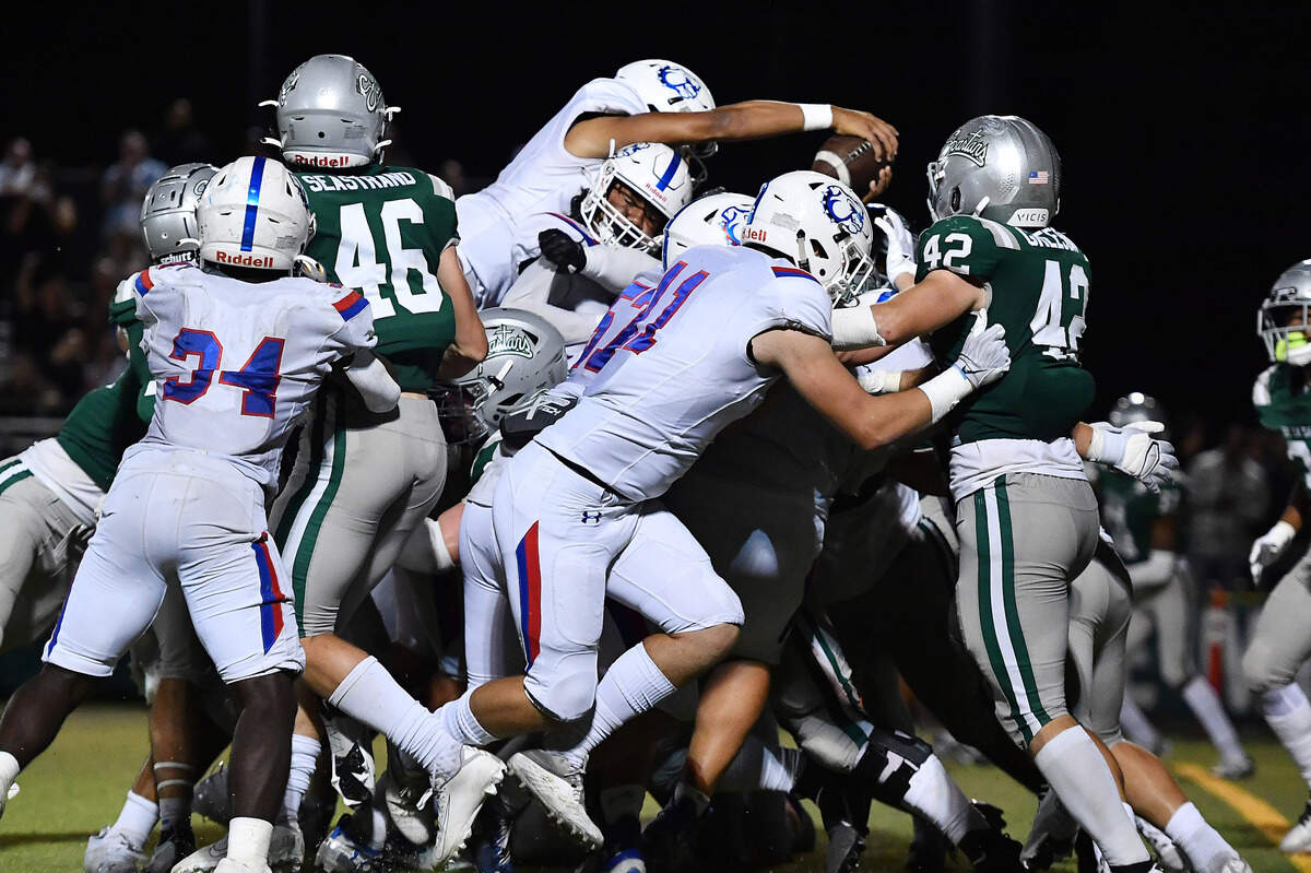 Folsom quarterback Austin Mack (12) leaps to score a two-yard touchdown during the fourth quarter of their game at De La Salle High School in Concord on Friday, Sept. 23, 2022. Folsom defeated De La Salle 24-20.