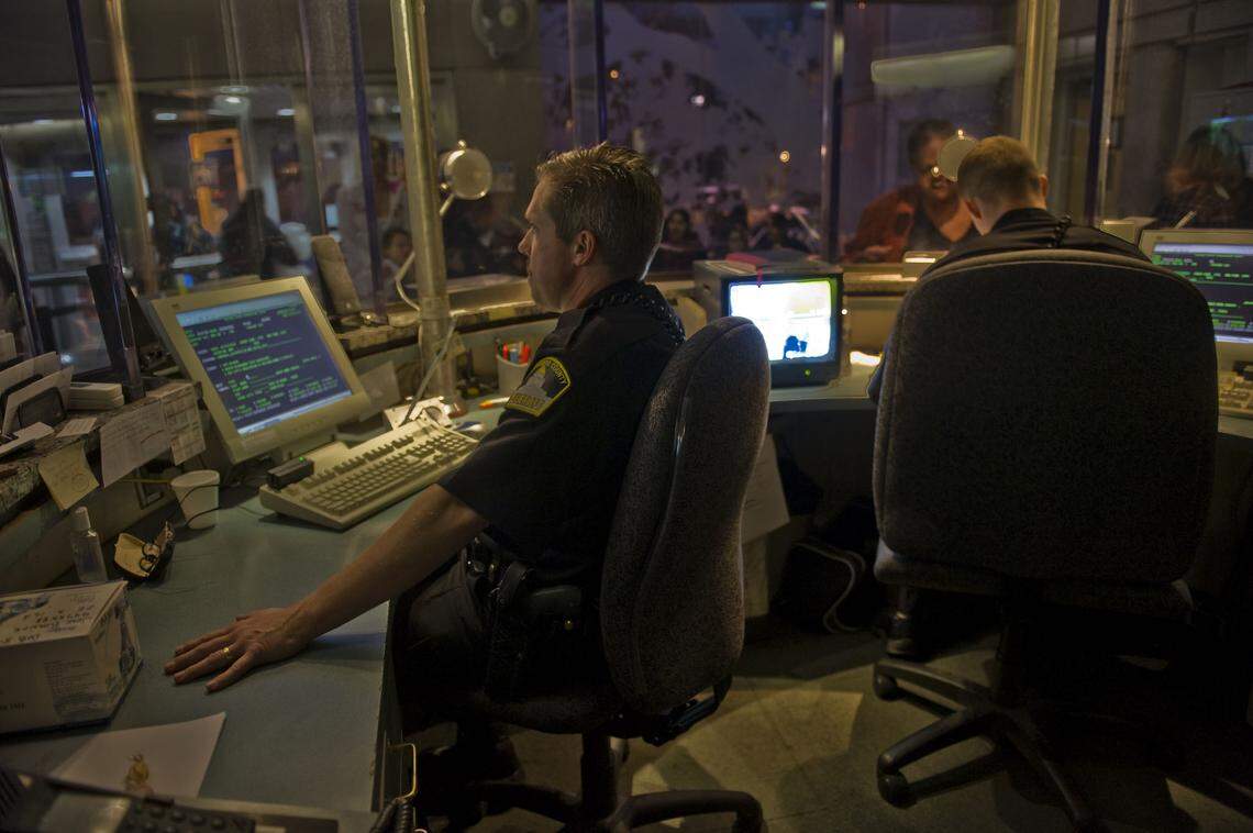 Sheriff’s deputies Tom Harrison, left, and Matt Carpenter, right, work the security windows at the Sacramento County Main Jail in 2010.