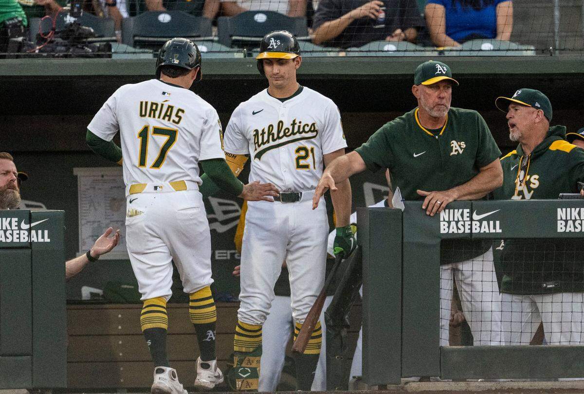 Athletics second baseman Luis Urías (17) is congratulated after scoring by outfielder Tyler Soderstrom (21) and manager Mark Kotsay against the Baltimore Orioles at Sutter Health Park on Friday.