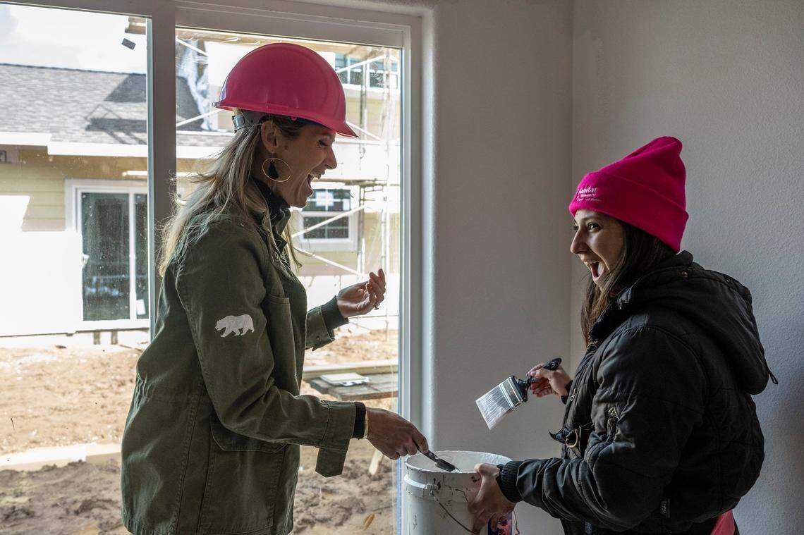 First Partner Jennifer Siebel Newsom shares a laugh with Monique Lujan as they paint Lujan’s home to celebrate International Women’s Day in Sacramento on Wednesday.