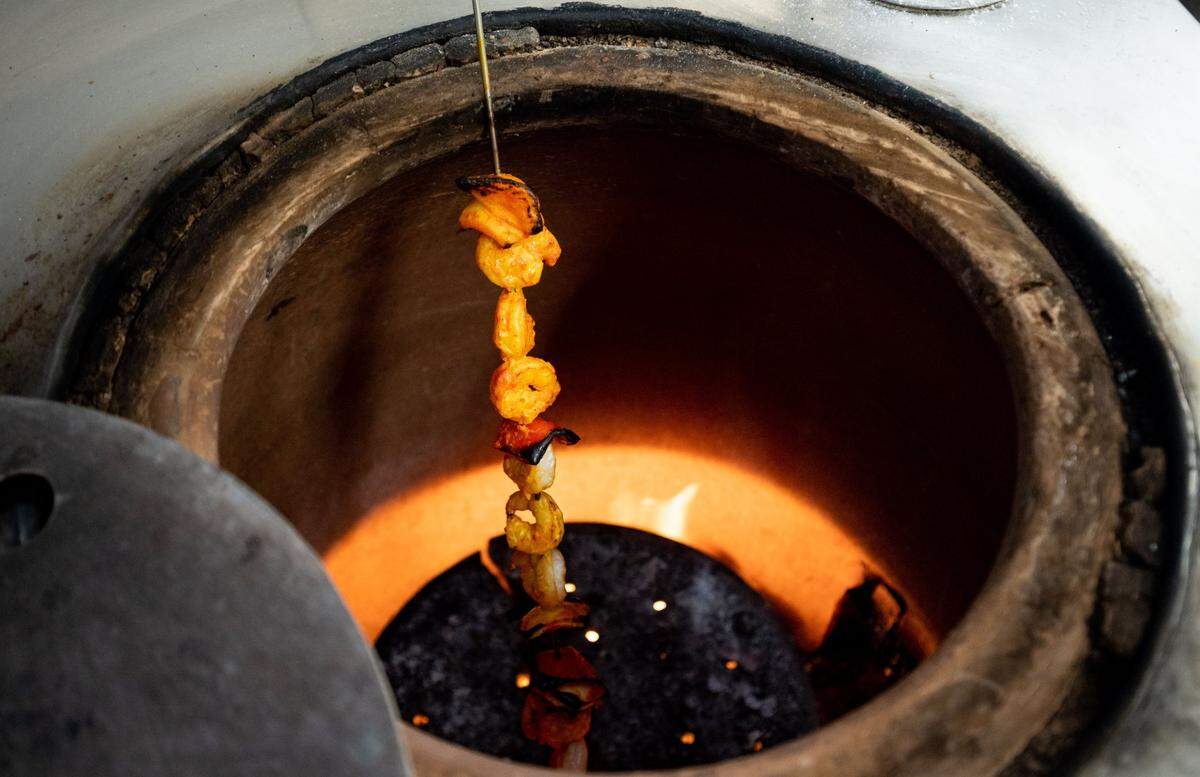 Shrimp cook in a tandoor, a cylindrical clay oven, at Jasdeep Singh Purewal’s Hop Junction on June 27, 2020. The restaurant offers a unique combination of craft beers and Indian food on Greenhaven Drive in Sacramento’s Pocket neighborhood.