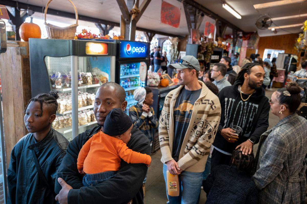 Charles Davenport of Sacramento stands at the front of the line with his daughter, Kayleigh, 15, and son Kingston 4-months old, to buy goods at High Hill Ranch on Saturday at Apple Hill.
