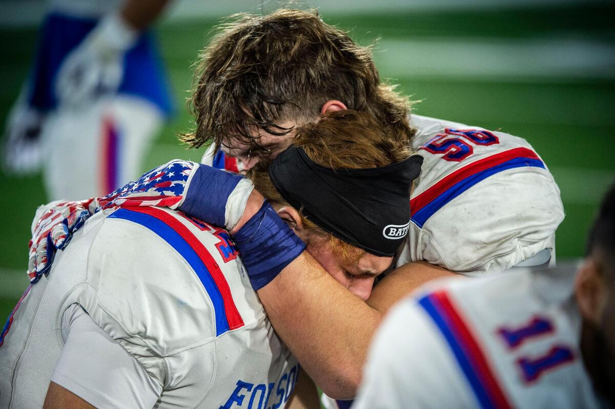 Folsom High School Lucas Wolfe (24) is comforted by teammate Folsom High School Lucas Hardeman (56) after their 33-21 loss against Cathedral Catholic during the CIF State Division I-AA Championship Saddleback College in Mission Viejo on Friday, Dec. 10, 2021.