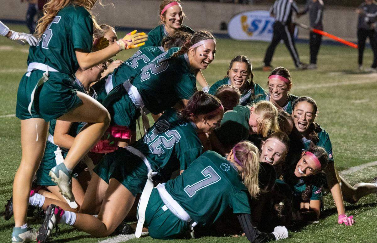 The Ponderosa Bruins dogpile on the field to celebrate winning the 2024 Sac-Joaquin Section Division II championship girls flag football game at Cosumnes River College. The school finished undefeated in its first season in the sport.