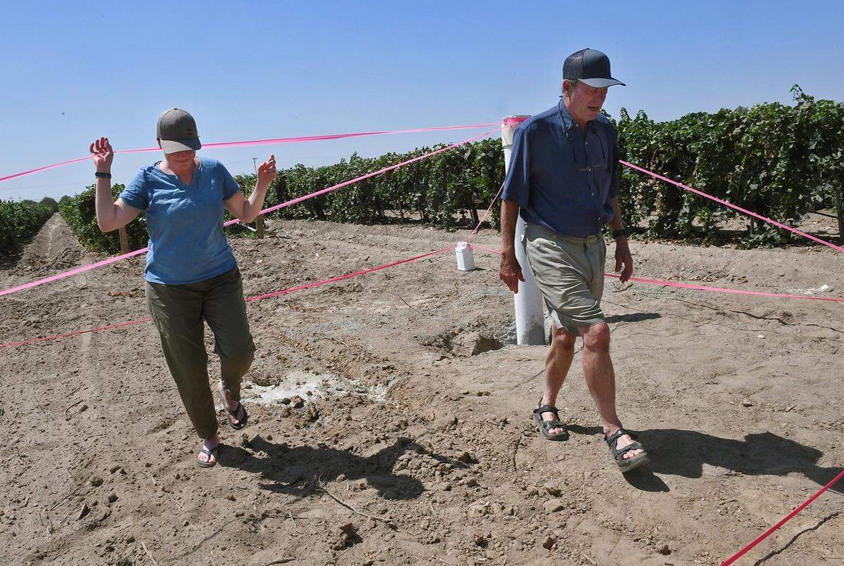 Andy Quady, owner of Quady Winery, right, walks with his daughter on in August to the site of a new well is being built after his original well began to go dry. Madera’s groundwater aquifer is falling quickly.