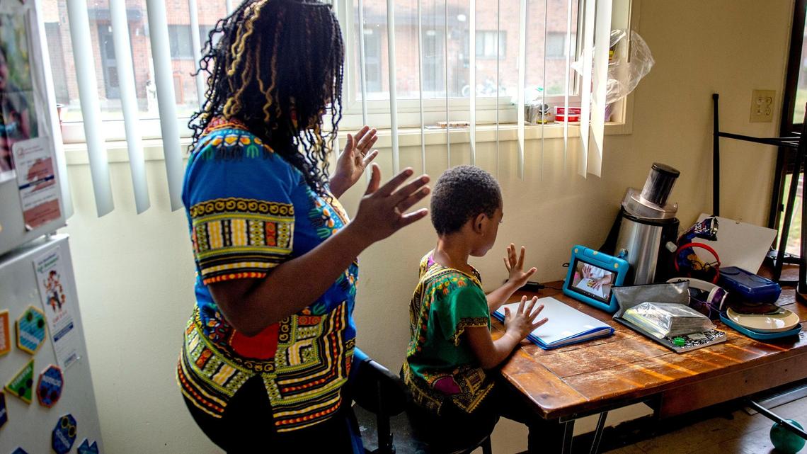 Marcheri Smith helps her first-grade son Tulley, 6, with his online distance learning from Leataata Floyd Elementary School in their Sacramento home, Friday, Oct. 2, 2020.