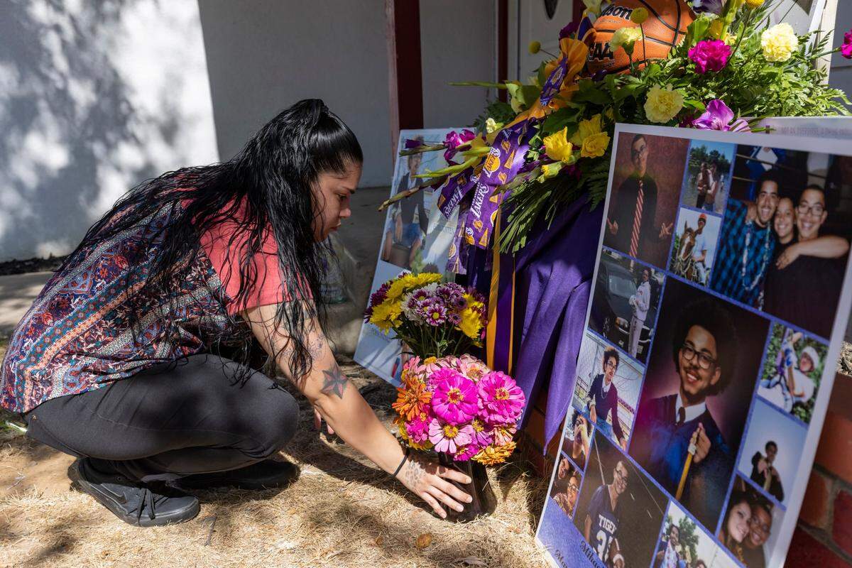 Allyssia Solorio arranges flowers at a memorial to her brother Mikael Tirado on the front porch in Rancho Cordova on Sept. 6, at a family gathering to mark the one-year anniversary of his death. Tirado died Sept. 7, 2020, from an accidental overdose from a pill that was illegally pressed as Percocet on the street but contained fentanyl.