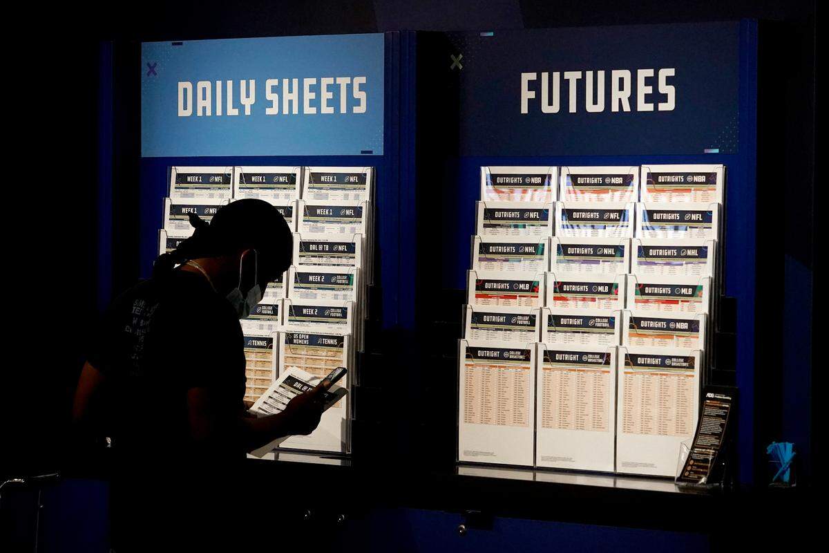 A customer looks over daily sheets inside FanDuel Sportsbook inside Footprint Center in Phoenix in September. Arizona’s first sports betting operations opened in time for the start of the NFL season with live wagers allowed on college and professional sports.
