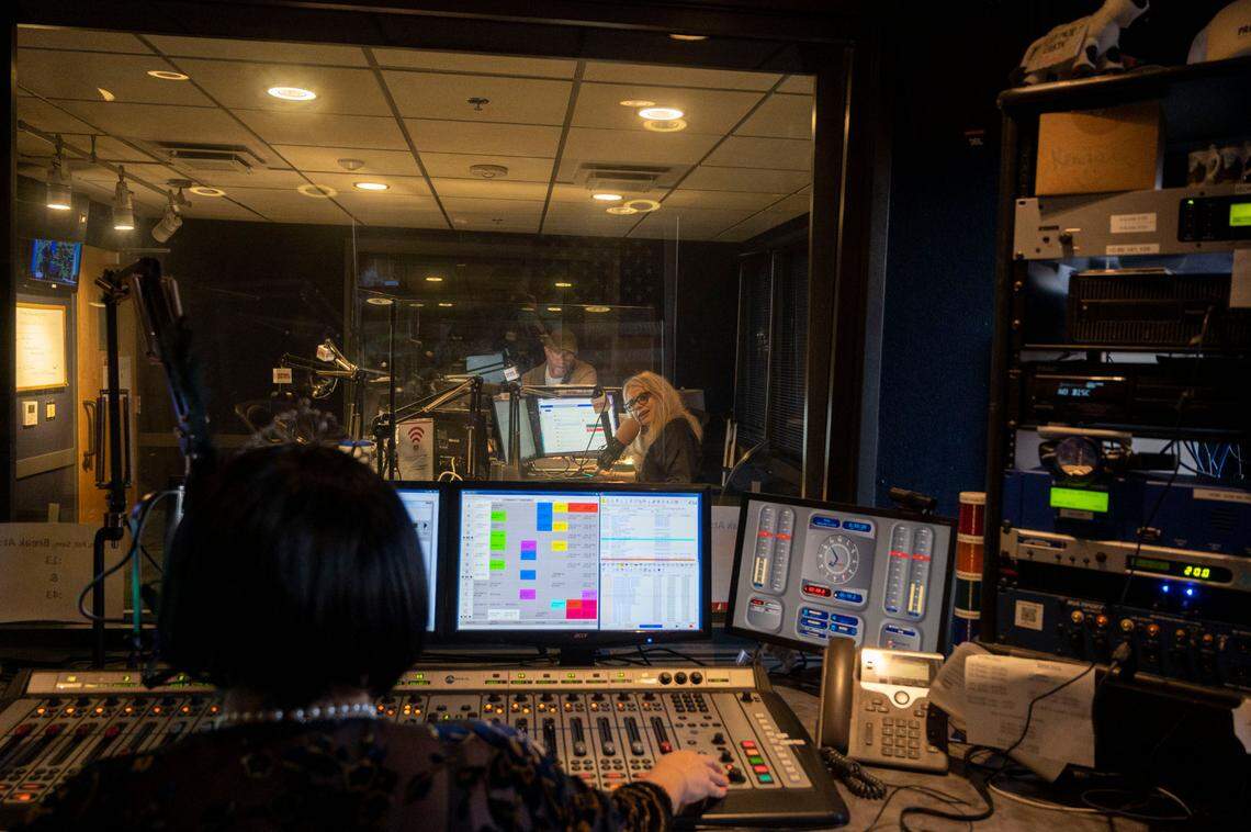 KFBK Newsradio anchors Pat Walsh and Kitty O’Neal talk to technical producer Kendall Tobe on Friday, Sept. 16, 2022, about the 100-year anniversary of the news radio station that launched on September 17, 1922. Tobe dressed up as a 1920s flapper girl for the occasion.