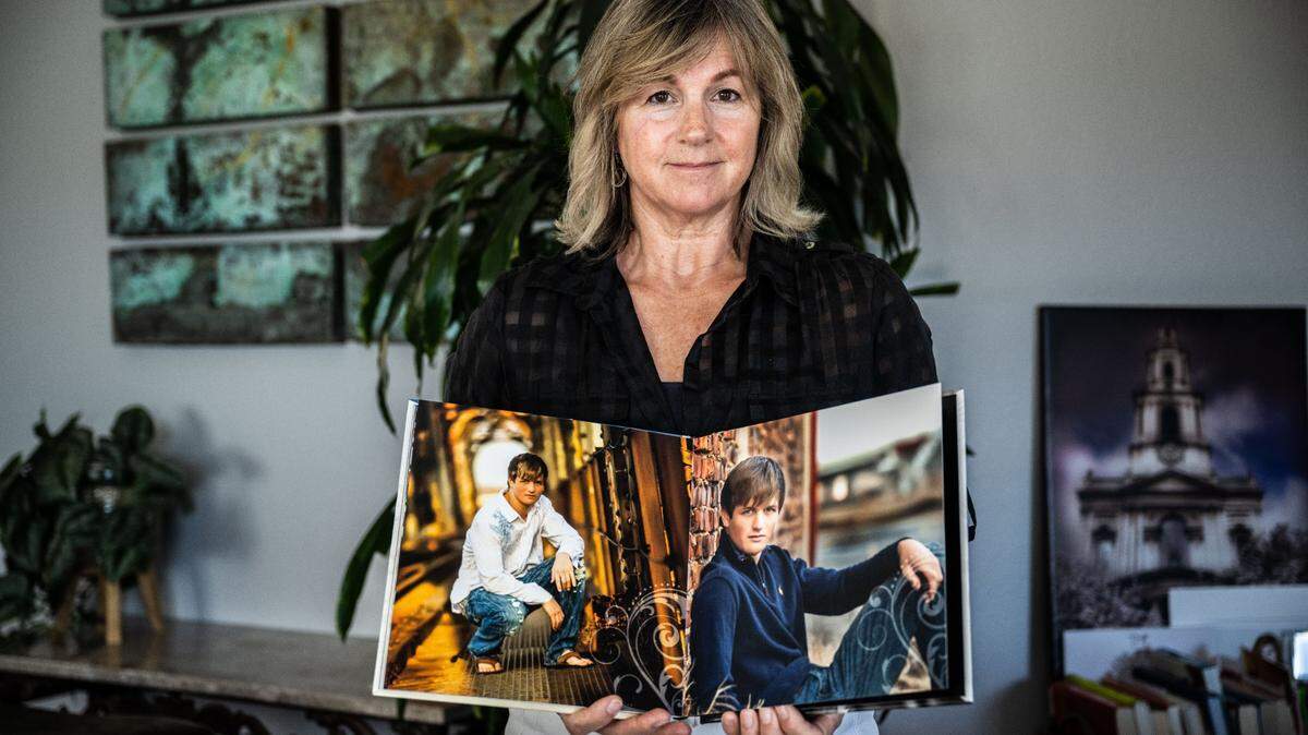 Deanna Hampton de Auburn sostiene un libro el jueves 27 de julio de 2023, con fotos de su difunto hijo Trevor, quien fue sometido a abusos por el padre Michael Kelly en la parroquia de St. Andrews en San Andreas. Trevor testificó sobre el abuso ante un jurado de instrucción en 2014, pero murió en un trágico accidente antes de que Kelly pudiera ser llevado a juicio.