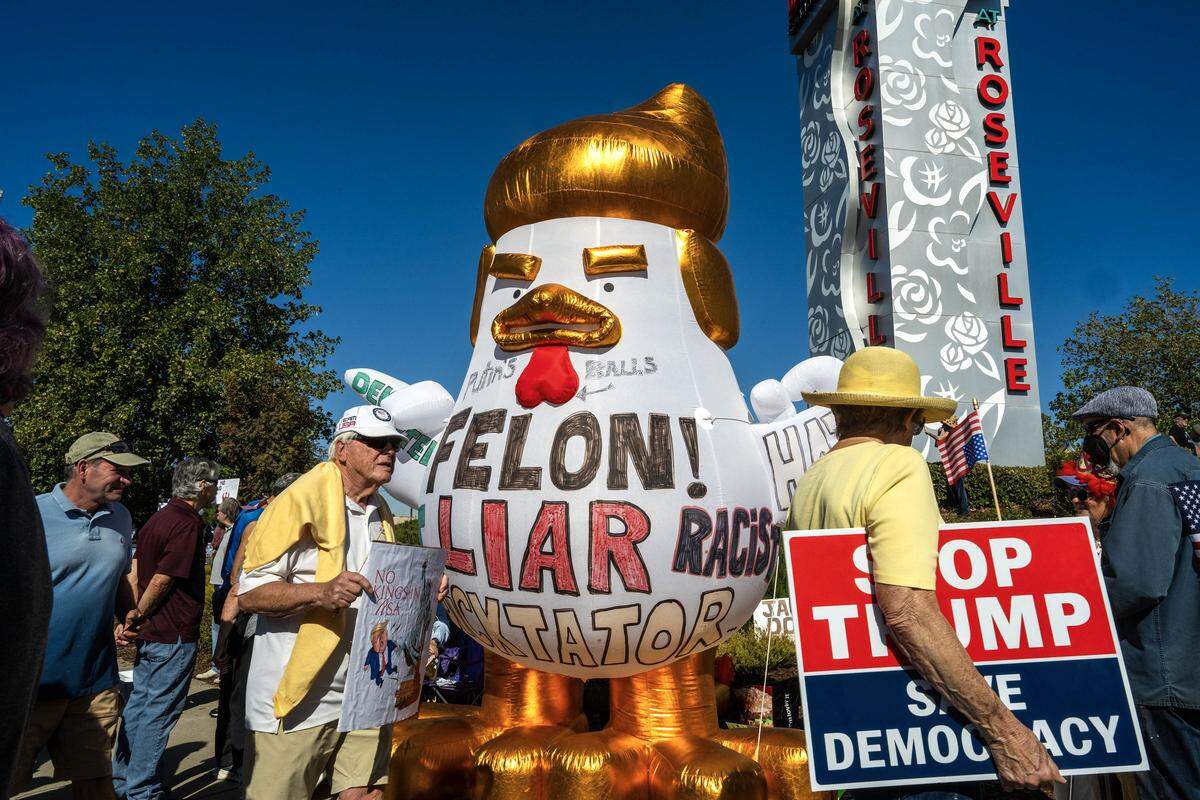 An inflatable chicken with golden highlights mimics President Donald Trump during a “No Kings” rally in Roseville on Saturday, Oct. 18, 2025.