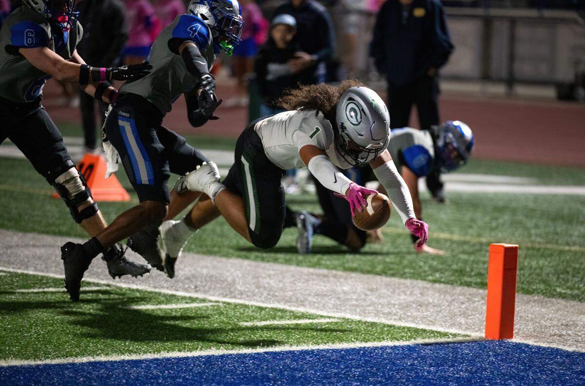 The Granite Bay Grizzlies’ Isaiah Ene (1) thrusts the ball over the goal line for a 27-yard touchdown run in the first quarter against Rocklin on Friday, Oct. 18, 2024, in Rocklin.