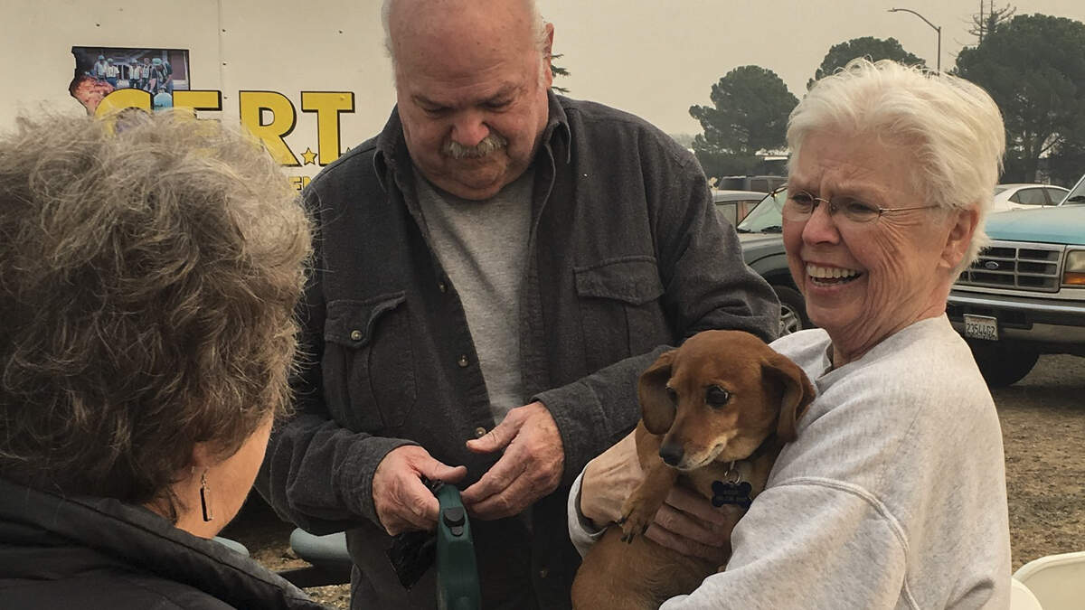 A family is reunited with their dog at the Chico Shelter during the Camp Fire in 2018, with the help the Sacramento Community Emergency Response Team (CERT), part of a nationwide volunteer response program guided by FEMA and run by regional fire departments.
