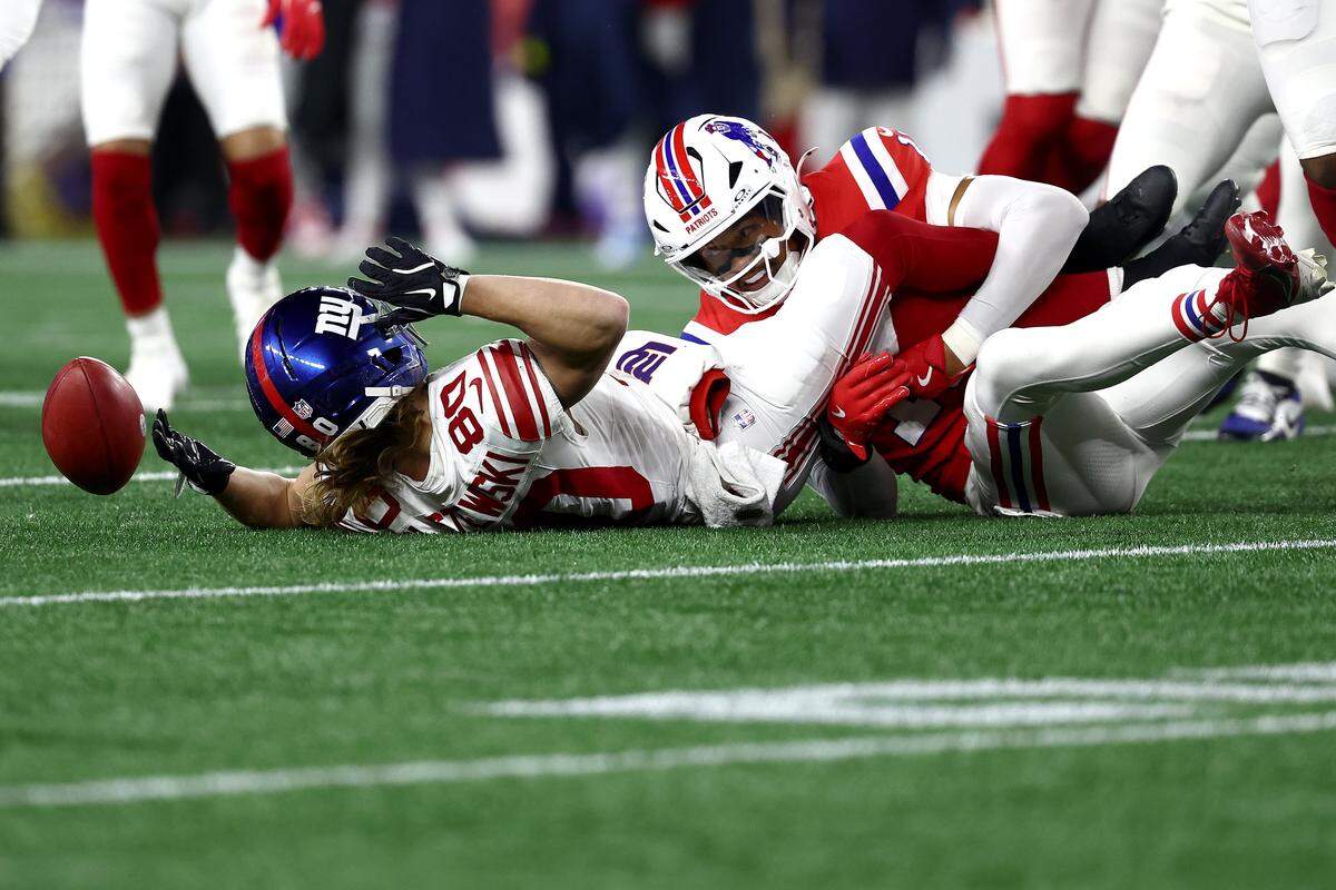 FOXBOROUGH, MASSACHUSETTS - DECEMBER 01: Gunner Olszewski #80 of the New York Giants fumbles after a hit by Marte Mapu #15 of the New England Patriots during the second quarter of the game at Gillette Stadium on December 01, 2025 in Foxborough, Massachusetts. (Photo by Winslow Townson/Getty Images)