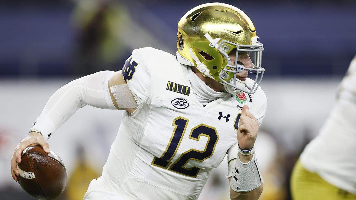 ARLINGTON, TEXAS - JANUARY 01: Quarterback Ian Book #12 of the Notre Dame Fighting Irish scrambles against the defense of the Alabama Crimson Tide during the 2021 College Football Playoff Semifinal Game at the Rose Bowl Game presented by Capital One at AT&T Stadium on January 01, 2021 in Arlington, Texas. (Photo by Tom Pennington/Getty Images)