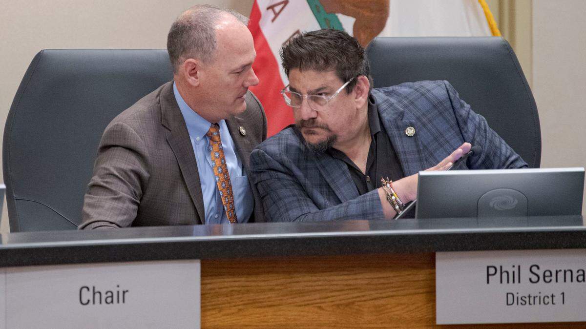 Sacramento County Supervisor Phil Serna, right, confers with Supervisor Rich Desmond during a board meeting earlier this year. 