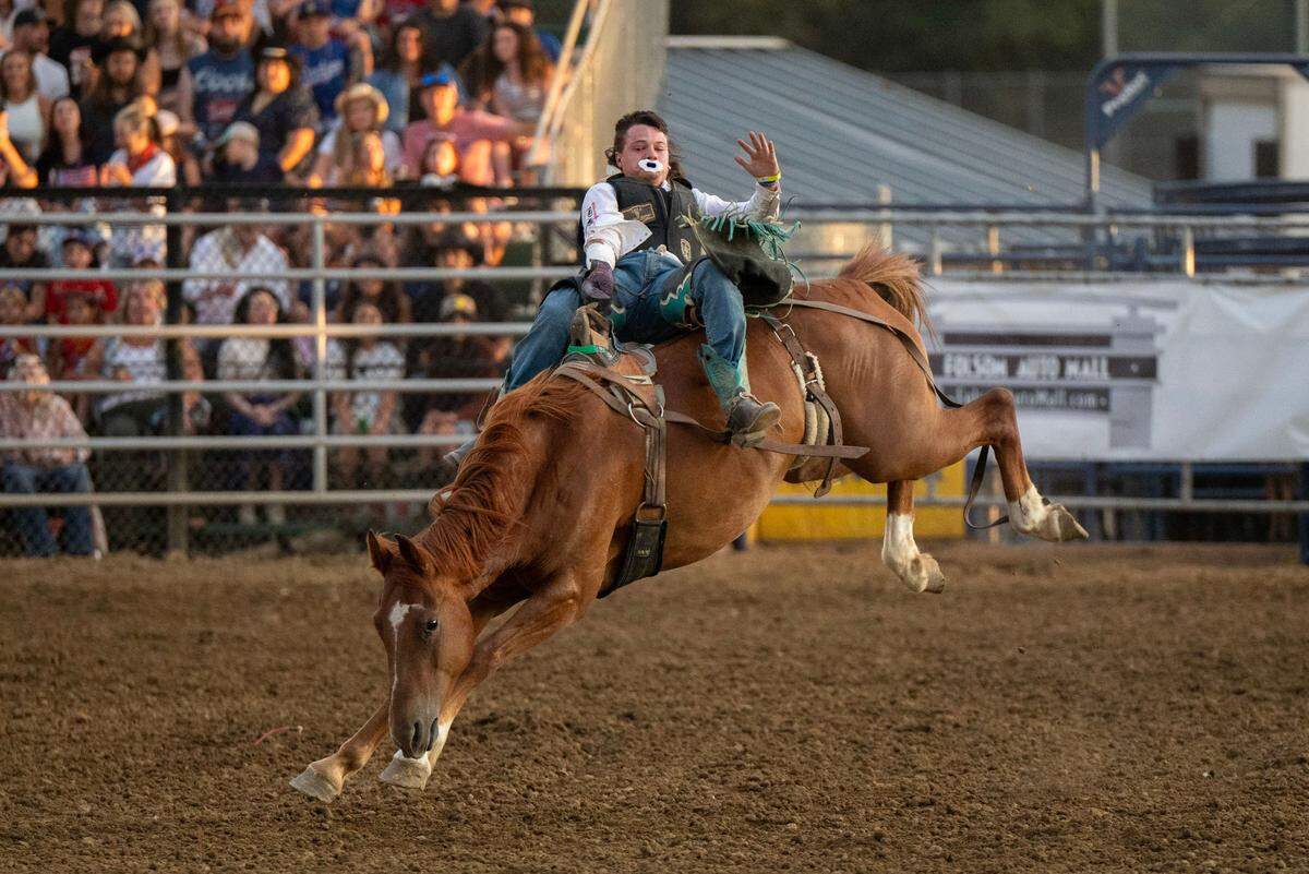 A bareback bronc rider attempts to hang on to a bucking horse for the required 8 seconds during the Folsom Pro Rodeo on Thursday.