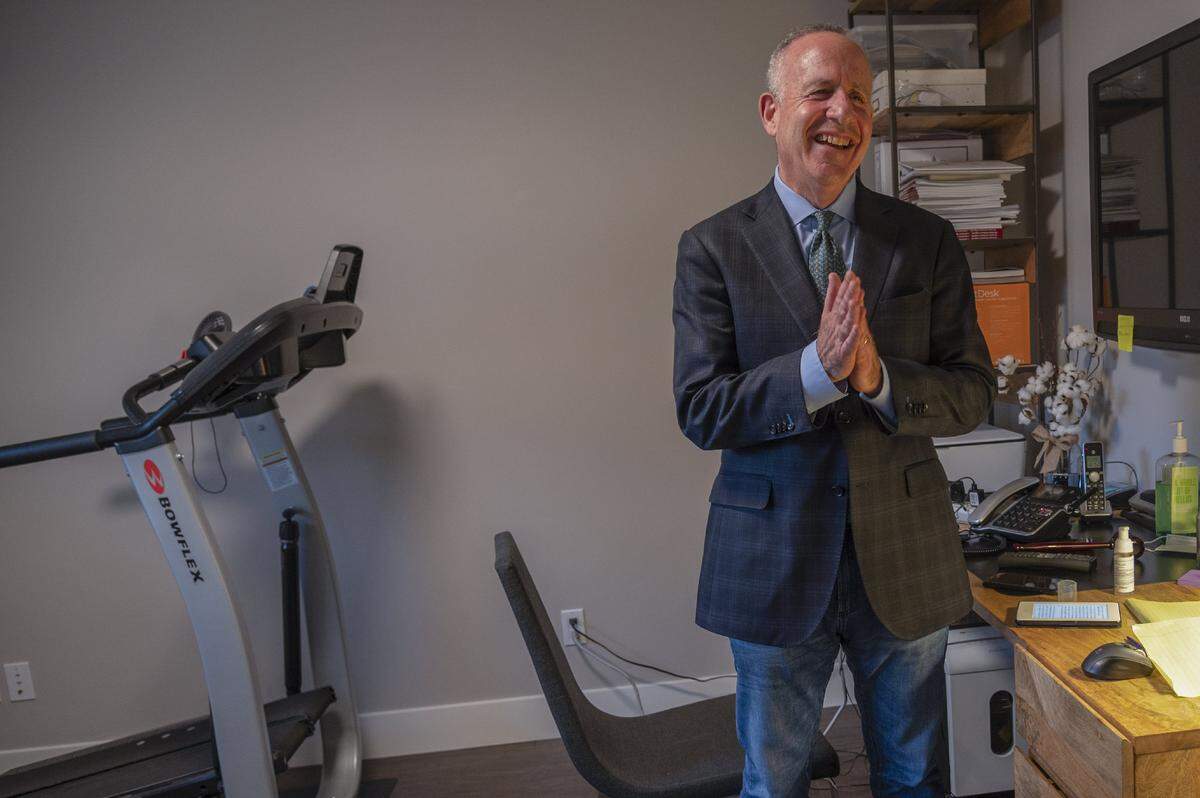Steinberg rubs sanitizer on his hands in his home office that doubles as an exercise room on April 22. He used the elliptical machine while the public tennis courts were closed because of the coronavirus concerns. He later said the office felt confining and depressing and moved to a room with more sunlight to work.