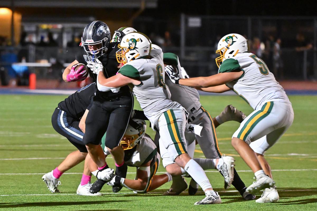 Vista del Lago Eagles wide receiver Matt Long (10) runs the ball with four Rio Americano Raiders’ defenders on him in the first half of the game on Friday, Oct. 13, 2023, at Vista Del Lago High School in Folsom.