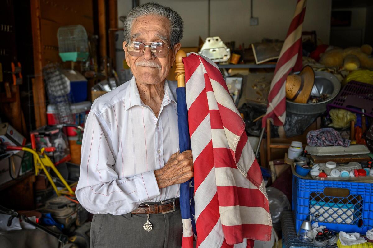Henry Guerrero holds one of many American flags that decorate his home on Tuesday, May 14, 2019. He came to the United States from Mexico during World War II under the bracero temporary worker program. WIth many soldiers fighting overseas, farm labor was in high demand. Guerrero left all he knew to come to a strange land.