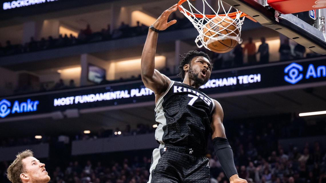 Sacramento Kings center Chimezie Metu (7) dunks the ball with an air assist from Sacramento Kings guard Davion Mitchell (15) past San Antonio Spurs center Jakob Poeltl (25), left, on Thursday.