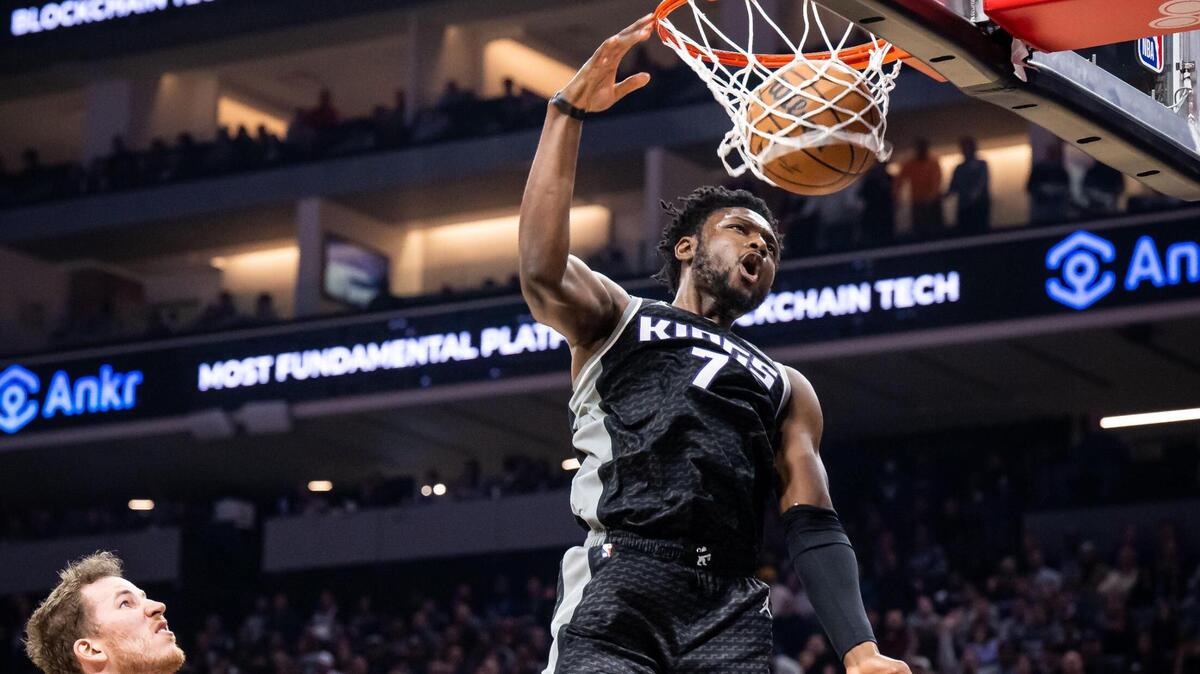 Sacramento Kings center Chimezie Metu (7) dunks the ball with an air assist from Sacramento Kings guard Davion Mitchell (15) past San Antonio Spurs center Jakob Poeltl (25), left, on Thursday.